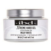 A jar of IBD Xtreme Hard Gel LED/UV Builder Gel in Milky White, featuring a white body, a metallic silver lid, and a black label with white text.