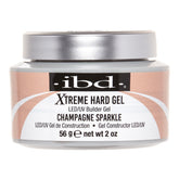 A jar of IBD Xtreme Hard Gel LED/UV Builder Gel in the shade Champagne Sparkle, featuring a metallic silver lid and a label with champagne glitter and white swooshes.