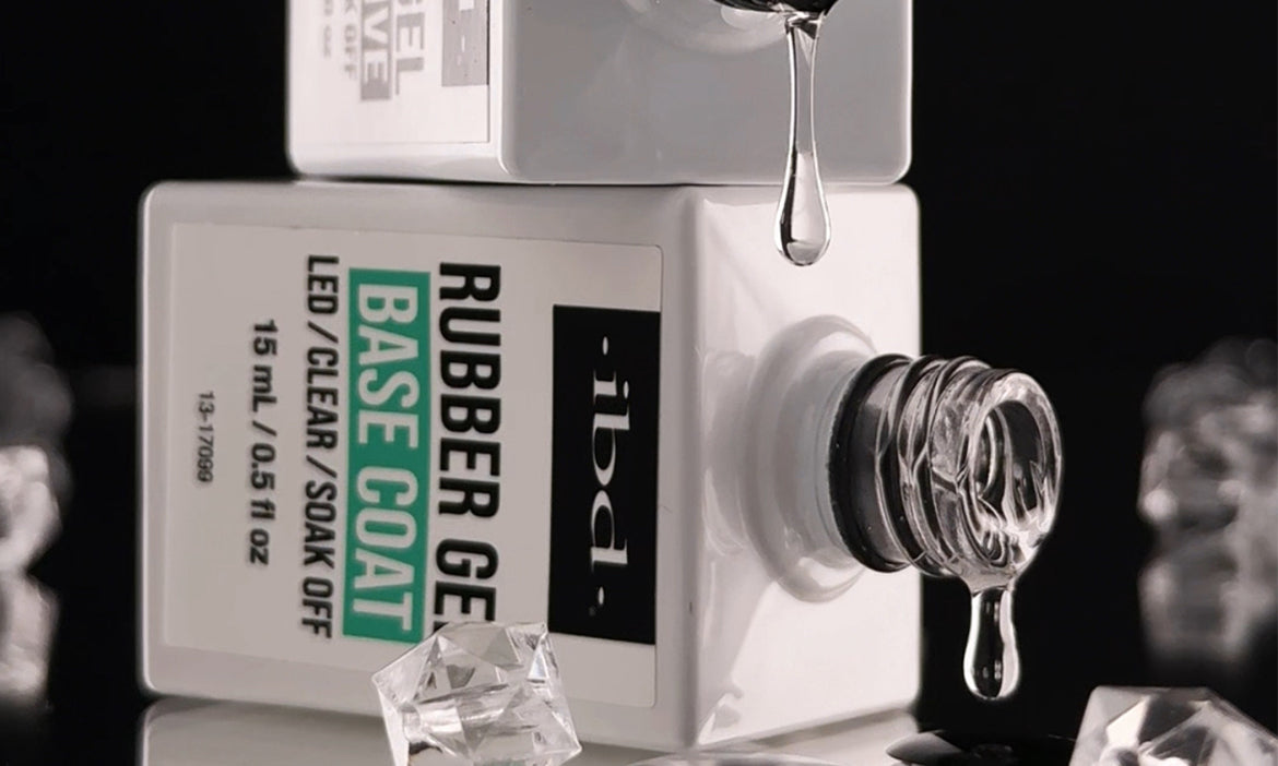 IBD rubber gel base coat bottle with clear gel droplets and crystal accents against a dark background.