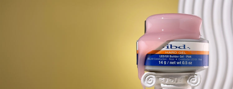 Jar of ibd Hard Gel colored pink on a yellow background