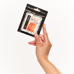 Model holding the sealed pack of IBD Soft Gel Tips and featuring the short almond tips on her nails